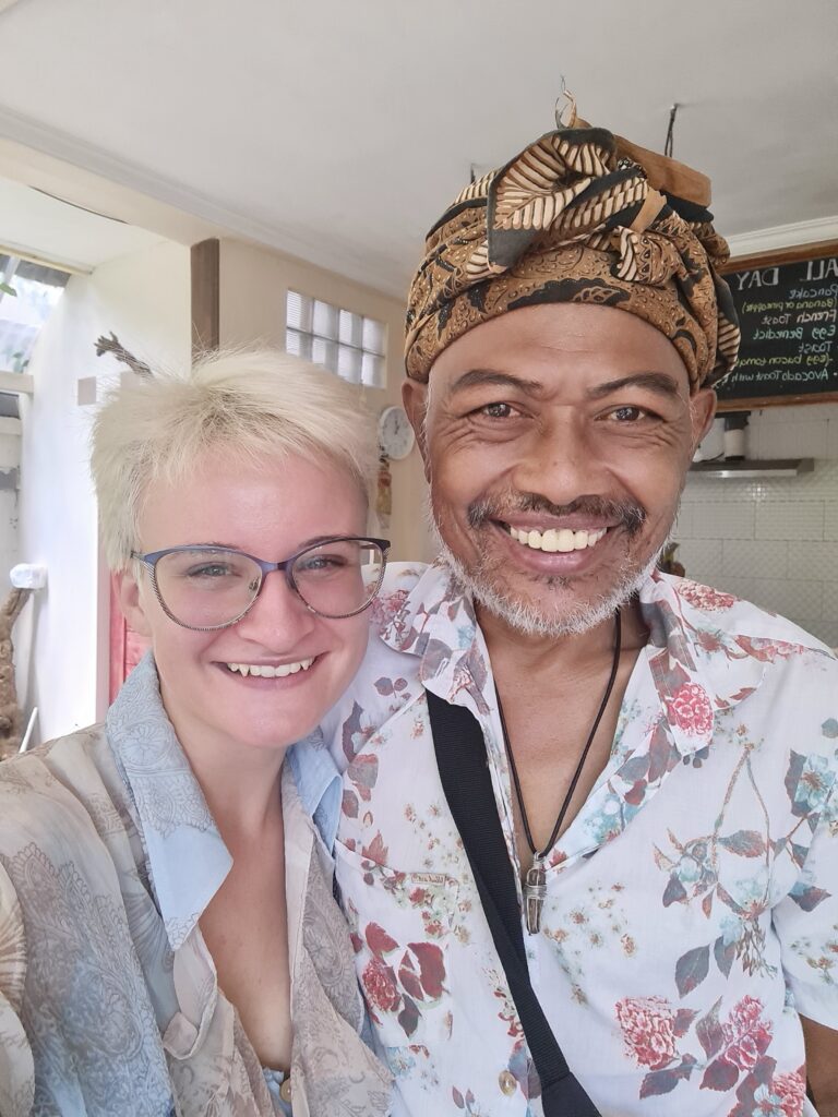 woman on left in blue blouse and short blonde hair, brown skinned man on left with flowery top. 