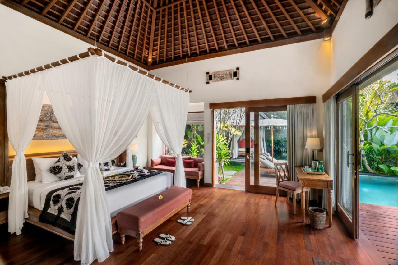 a double sized bed with large mosquito nets is shown on the left. Dark wooden floors led through the French windows towards the private pool which is on the left. The ceiling is high.